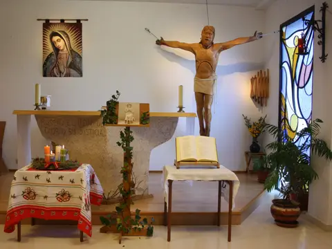 capilla de la casa, con el altar, el crucifijo y la vidriera