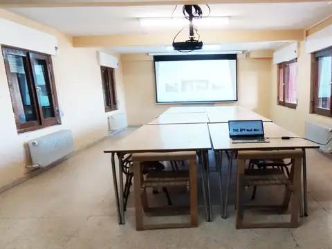 sala de reuniones con las mesas en U, pantalla y proyector