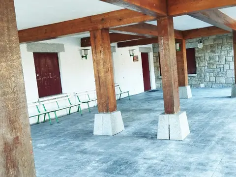 porche cubierto de actividades, con los bancos y la barbacoa de piedra