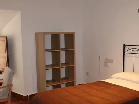 dormitorio de la casa sacerdotal, con cama individual y estantería