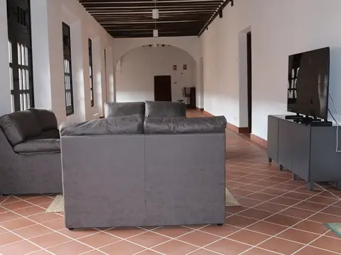 sala de estar común de la casa sacerdotal, con sofás y televisión