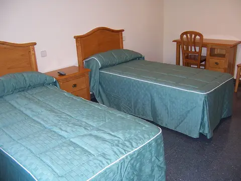 habitación doble con dos camas, escritorio y sillas