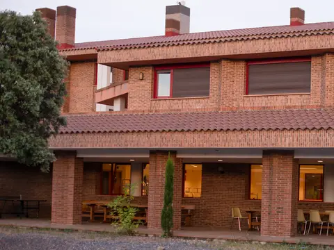 edificio de ladrillo del centro con el porche corrido y las mesas del exterior