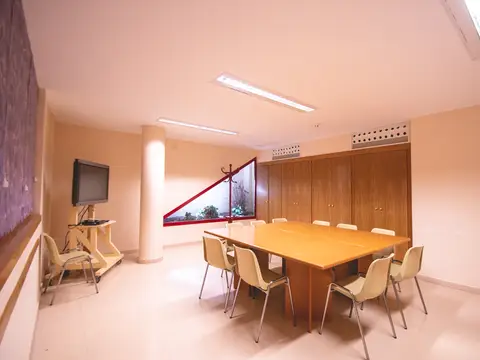 sala reservada con mesa de reuniones y pantalla