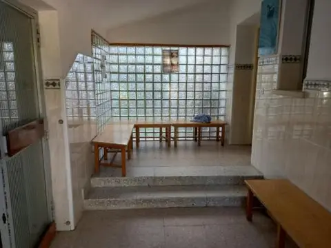 vestíbulo interior con bancos y la pared de pavés