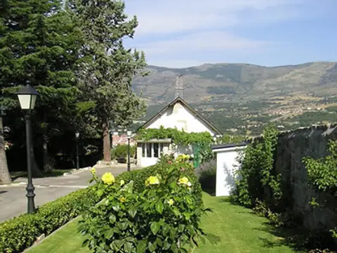 jardín del centro con el prado de rosales y la sierra al fondo