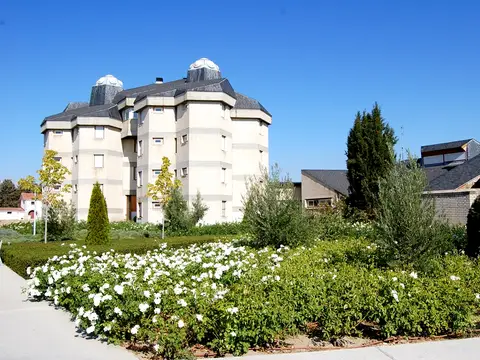 las torres características de Santa María de Los Negrales, vistas desde el jardín en flor