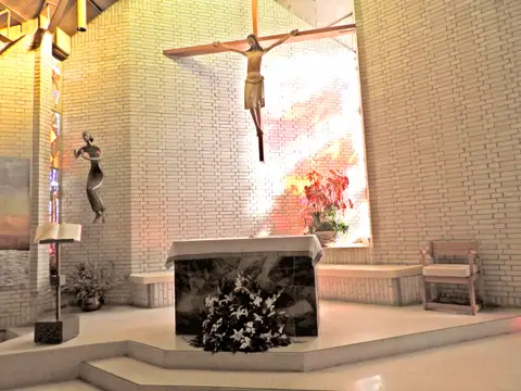 capilla del centro, con el crucifijo sobre el muro de ladrillo y el altar de piedra
