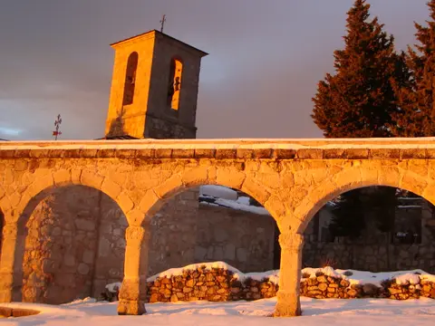 arcadas y campanario del convento al atardecer, con nieve