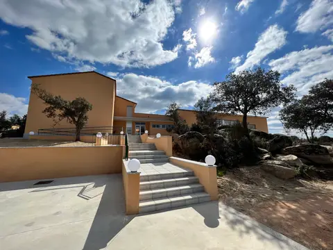 fachada de la casa nueva de eventos, con la escalera de acceso y las encinas