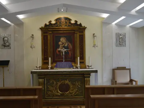 oratorio de la casa, con el retablo y los reclinatorios