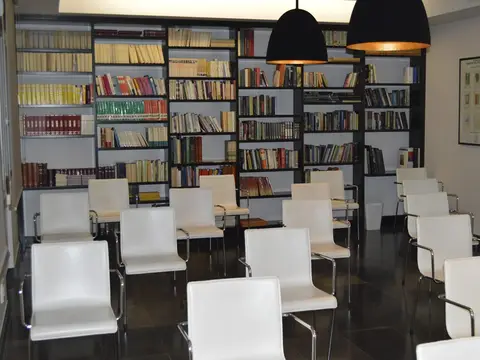 sala-biblioteca con estanterías de libros y sillas colocadas para una charla