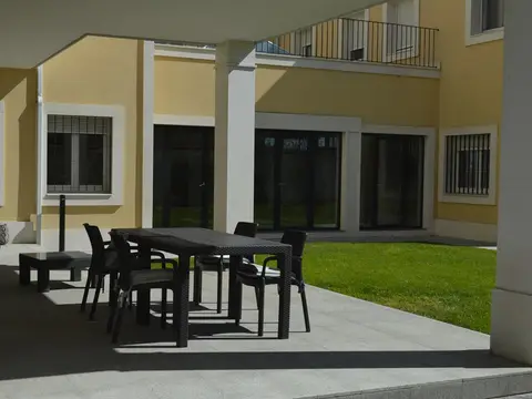 porche exterior con mesas junto al jardín