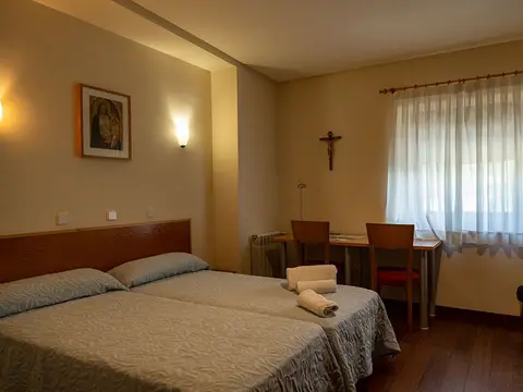 habitación doble del alojamiento monástico, con el crucifijo y la ventana al valle