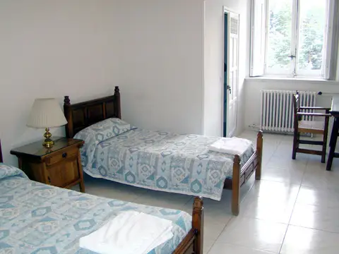 habitación doble de la hospedería, con dos camas de madera y ventana