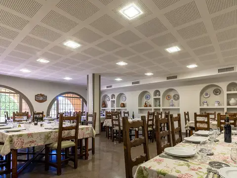 comedor con las mesas puestas y los arcos de la pared del fondo