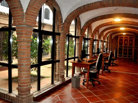 galería abovedada de ladrillo con los puestos de trabajo y los ventanales al jardín