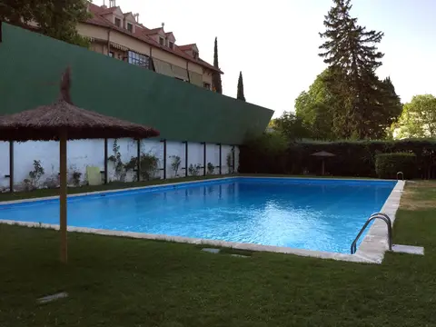 piscina y jardín de la casa, con la pérgola y el arbolado