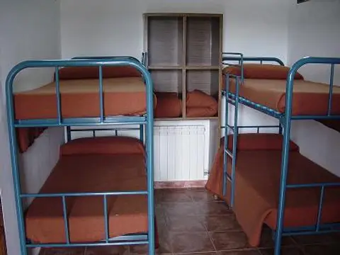 habitación con literas metálicas y armarios