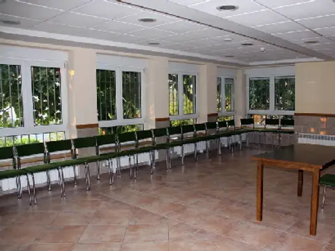 sala de reuniones con las sillas colocadas y ventanales al jardín