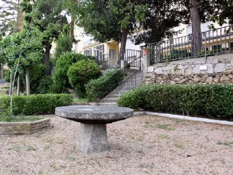 jardín de la casa con la fuente de piedra y los setos