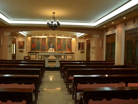 oratorio de la casa, con los bancos de madera y el retablo del altar