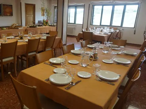 comedor con las mesas puestas y las ventanas al jardín