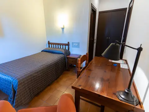 habitación individual con cama, escritorio y armario