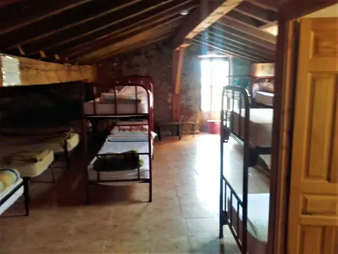 dormitorio de literas bajo la cubierta de vigas de madera