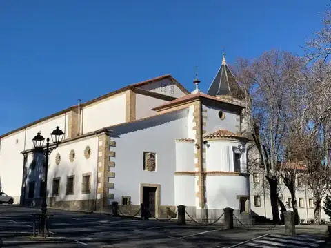 exterior del conjunto del Santuario de Nuestra Señora del Castañar desde la Plaza de los Tilos: la iglesia encalada con su cimborrio y el edificio anexo de los Padres Teatinos donde está la casa de espiritualidad