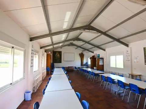 sala grande de reuniones bajo cubierta de vigas, montada con mesas corridas