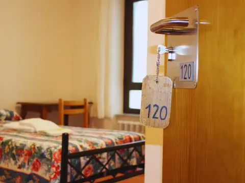 habitación individual de la casa, con la puerta numerada y la mesa de trabajo