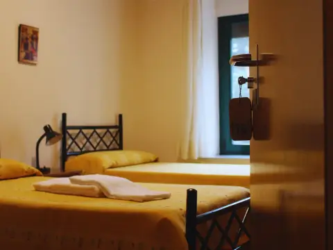 habitación doble con dos camas y ventana al jardín