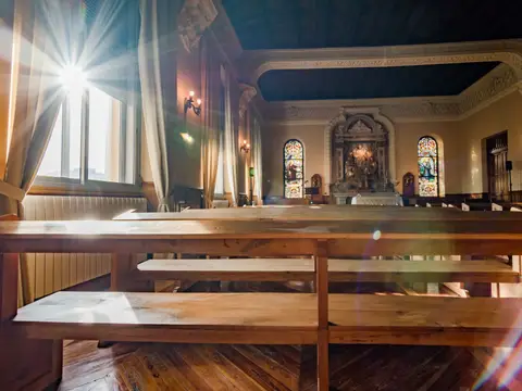capilla principal del centro, con los bancos corridos de madera y las vidrieras