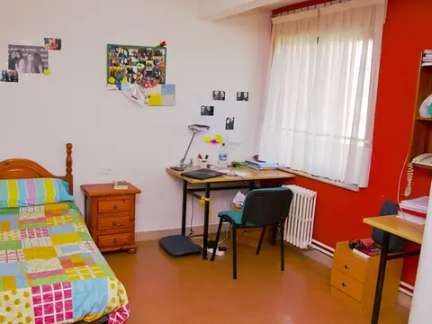 otra de las habitaciones del colegio, amueblada y con escritorio junto a la ventana