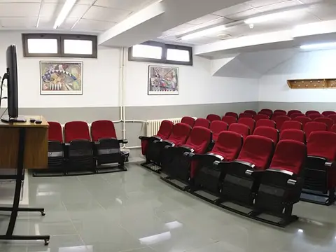 salón de actos del colegio, con las butacas rojas
