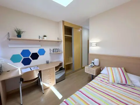 habitación individual del colegio, con escritorio amplio, armario y baño privado