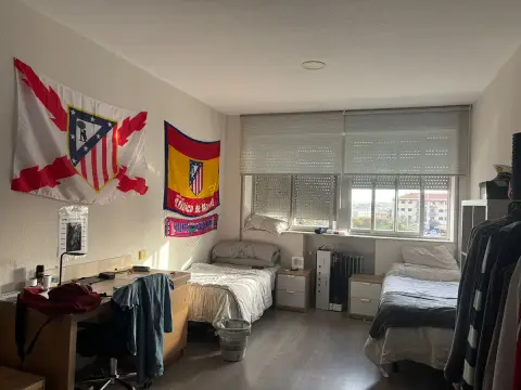 habitación de colegial, con cama, mesa de estudio y baño propio