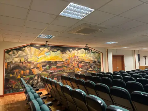 salón de actos del colegio, con el mural del testero