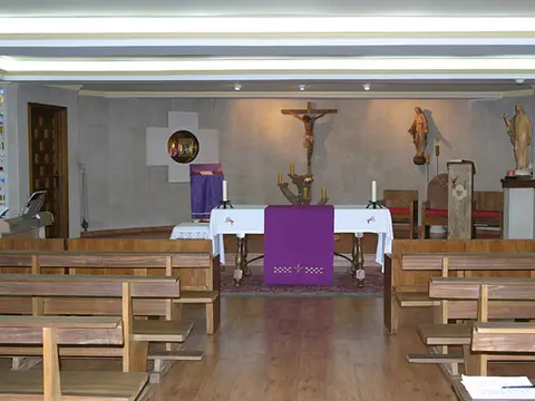 capilla de la hospedería, con el altar y los bancos de madera