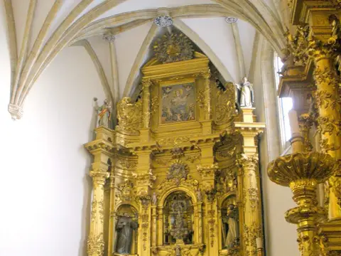 interior de la iglesia del monasterio, con el retablo dorado y las bóvedas de crucería