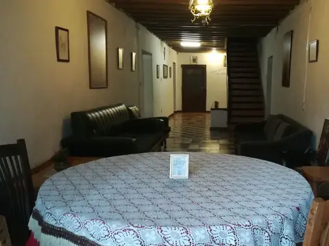 sala de estar de la hospedería, con mesa camilla y sofás junto al pasillo