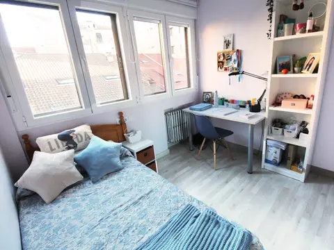 habitación individual con escritorio y ventana a los tejados