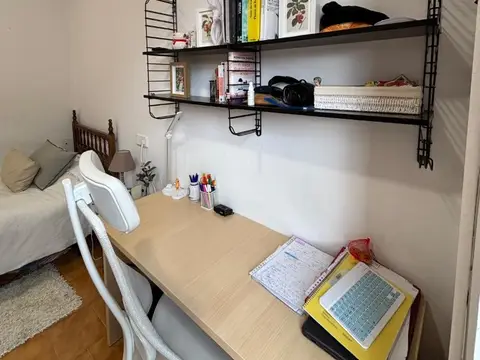 habitación abuhardillada de la última planta, con escritorio y estanterías