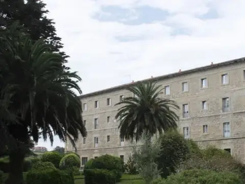 fachada (edificio principal con palmeras y jardín)