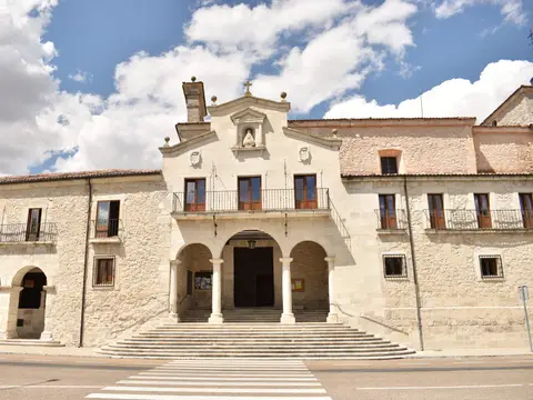 fachada del santuario de El Henar desde la pradera: la iglesia y, a los lados, las alas con soportales del conjunto donde están la casa de espiritualidad y las dependencias