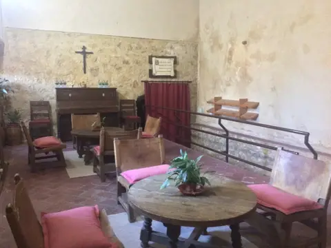 sala de estar del centro, con armonio y muros de piedra