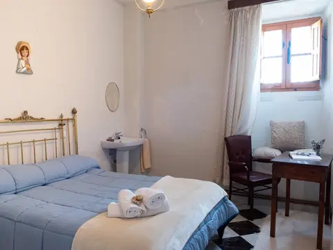 dormitorio con cama de matrimonio y lavabo, en la Casa Santa Inés