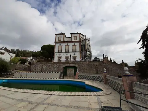 el edificio con el jardín y la piscina, sobre la sierra