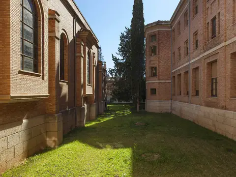 jardín y fachada lateral de ladrillo del edificio